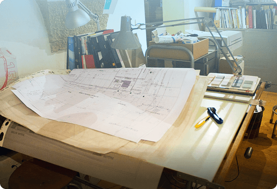 Architectural plans on a desk with regulatory documents